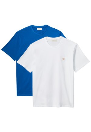Weiße und blaue T-Shirts mit kurzem Ärmel und Rundhalsausschnitt, weißes T-Shirt mit kleinem rotem Logo in der Mitte der Brust, darüber ein blaues T-Shirt getragen.