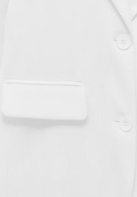 Biały żakiet z kieszonką naszywaną, dwoma guzikami i gładką teksturą. Design jest prosty, bez widocznych wzorów czy akcentów.