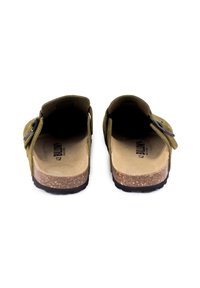 Des sandales à glissière en suede vert avec un semelle en liège, une bride réglable avec une boucle en métal, une semelle intérieure texturée et une semelle en caoutchouc noir.