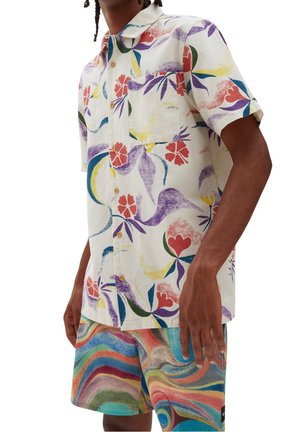 Korte mouwen, knopenoverhemd in crème met kleurrijke bloemen- en abstracte patronen; gecombineerd met meerkleurige golvende shorts.