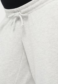 Light gray sweatpants with a drawstring waistband, a soft texture, and a relaxed fit, captured from a close-up angle.