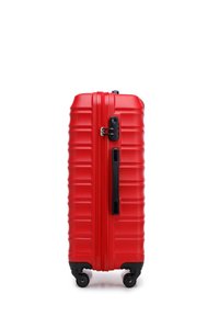 Red hard-shell suitcase with a textured surface, horizontal grooves, and a black zipper. Features four wheels and a side handle for easy maneuvering.