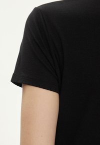 T-shirt in cotone nero con collo a giro e maniche corte. Tessuto morbido e cuciture pulite lungo i bordi.