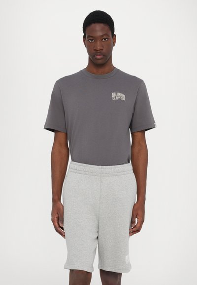 Grå bomulds t-shirt med et logo på brystet, parret med lysegrå shorts med elastisk talje lavet af et blødt, tekstureret stof.