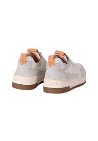 Sneaker in suede grigio chiaro con accenti arancioni, punta rotonda, suola in gomma marrone spessa e dettagli di cucitura a contrasto sul tallone.