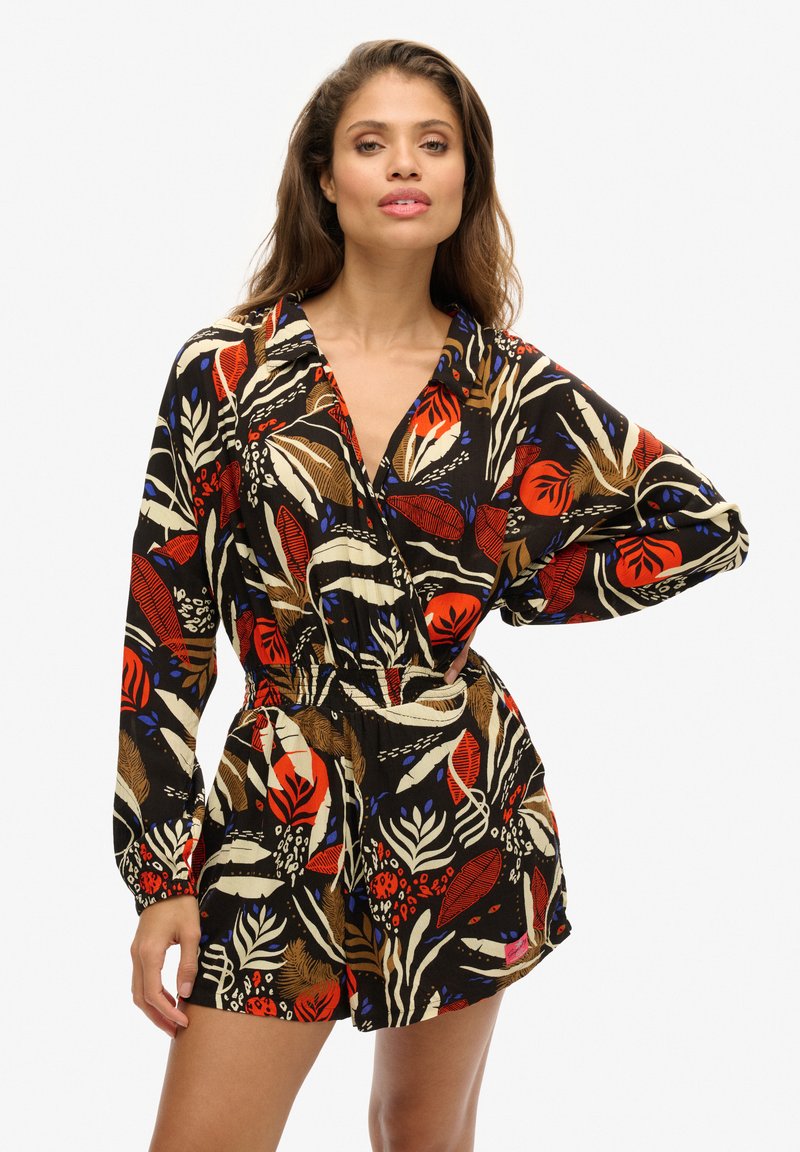 Monos de flores negros con patrones vibrantes en rojo, azul y blanco. Mangas sueltas y una cinturilla elástica para un ajuste relajado.