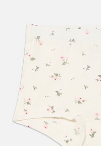 Bomuldstrusser i creme med blomsterprint. Har små lyserøde blomster og grønne blade. Blød tekstur med elastisk linning.