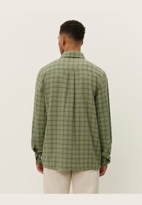 Groene geruite overhemden met lange mouwen, gemaakt van textuurstof, met een kraag, knopenmanchetten en een rechte zoom op de taille.