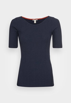 Navy blue ribbed short-sleeve top with scoop neckline and slim fit, featuring a small red trim inside the collar.
