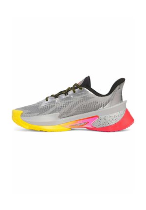 Silberne Sportschuh mit einem Obermaterial aus Mesh, schwarzen Akzenten, einer gelben und pinken Sohle, strukturierten Mustern sowie schwarz gesprenkelten Details an der Ferse.
