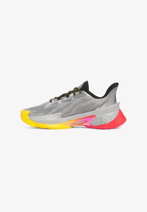 Silver athletic shoe with a mesh upper, black accents, yellow and pink sole, textured patterns, and black speckled detailing on the heel.