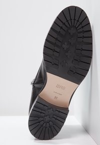 Scarpa nera in pelle con suola in gomma. La suola presenta un motivo testurizzato e dettagli del marchio in rilievo, taglia 37. Prodotta in Italia.