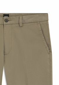 Beige Hosen aus einem Baumwollmischgewebe, mit einem Knopfverschluss, Gürtelschlaufen, Seitentaschen und leichter Textur mit feiner Webart.