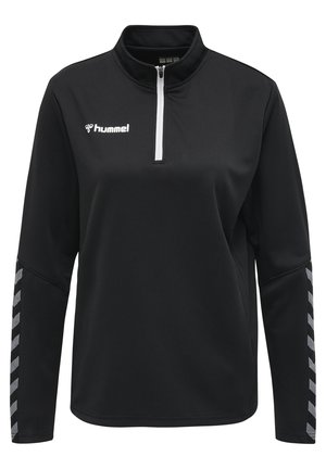 Sort quarter-zip pullover med tekstureret stof. Har hvid lynlås og "hummel" logo. Grå chevron mønster på ærmerne.