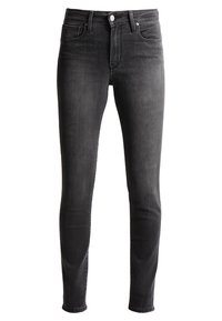 Jeans noirs slim fit avec cinq poches, fermeture avant par bouton et zip, présentés sur un fond blanc.