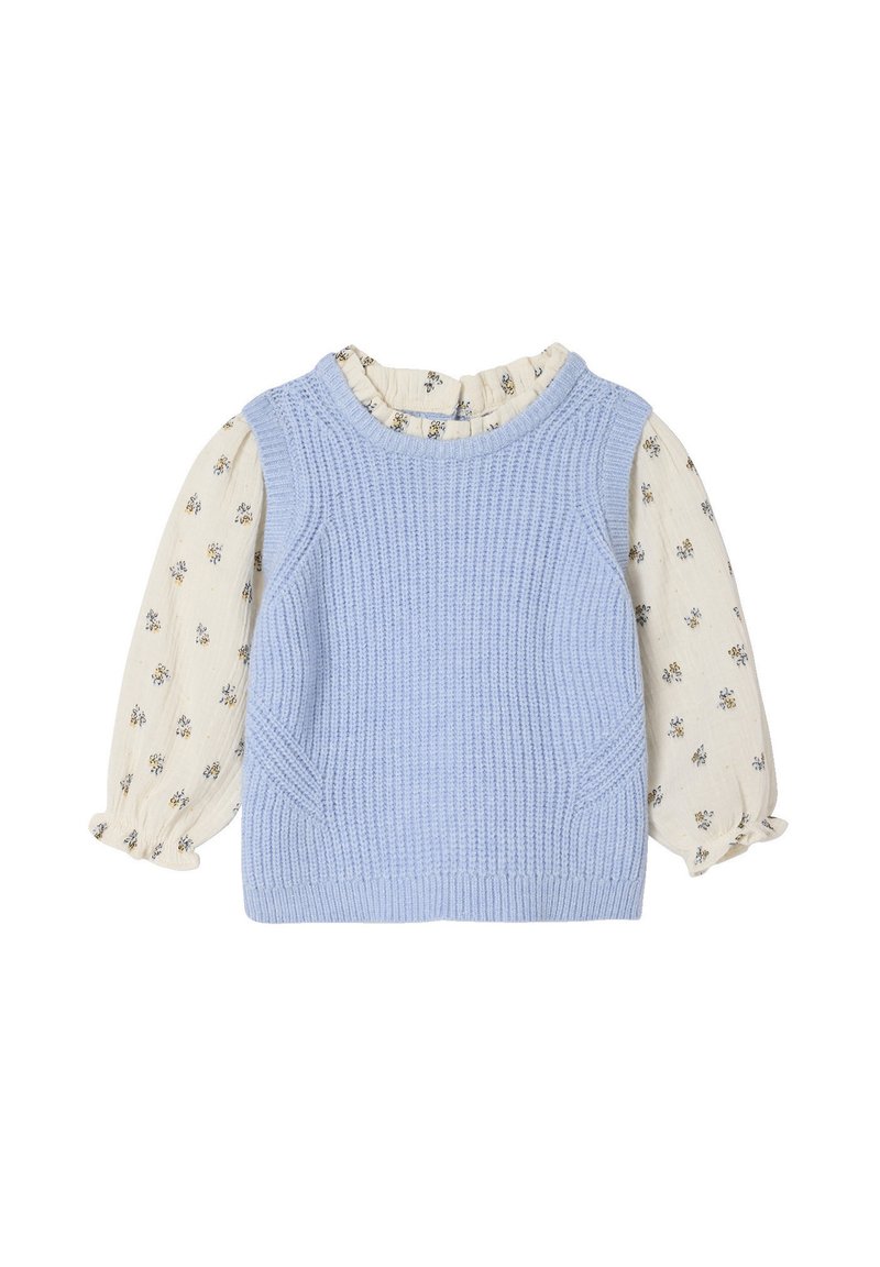 Helles blauer Strickwesten mit geripptem Textur, kombiniert mit einer cremefarbenen Bluse mit Blumenmuster und Puffärmeln.