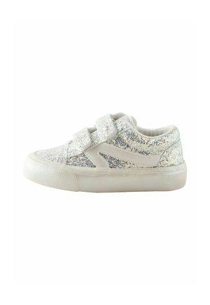 Hvid børnesneaker med sølvglitter, to velcrolukninger og en tyk tekstureret gummisål, vist fra siden på en hvid baggrund.