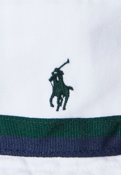 Bijela pamučna šeširica sa zelenom i tamnoplavom prugastom trakom. Ima izvezeni zeleni logo igrača polo na prednjoj strani.