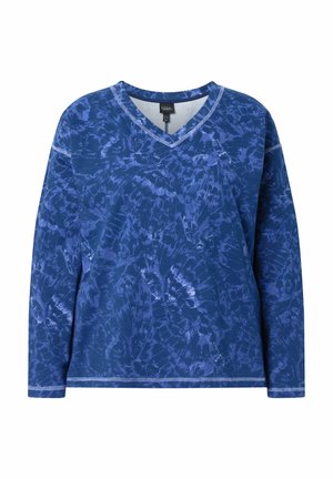 Langärmeliges, blau gefärbtes V-Ausschnitt-Shirt mit sichtbaren weißen Nahtdetails an Bündchen, Saum und Ausschnitt vor weißem Hintergrund.