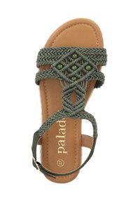 Tomaia in tessuto intrecciato verde oliva con perline decorative, soletta in pelle beige, cinturino alla caviglia regolabile, suola piatta. Logo del marchio visibile.