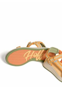 Sandalia ajustable con tiras trenzadas en naranja y beige, suela gris claro y suela con patrón de espiga naranja, con el logo 'Hoff' en la parte inferior.