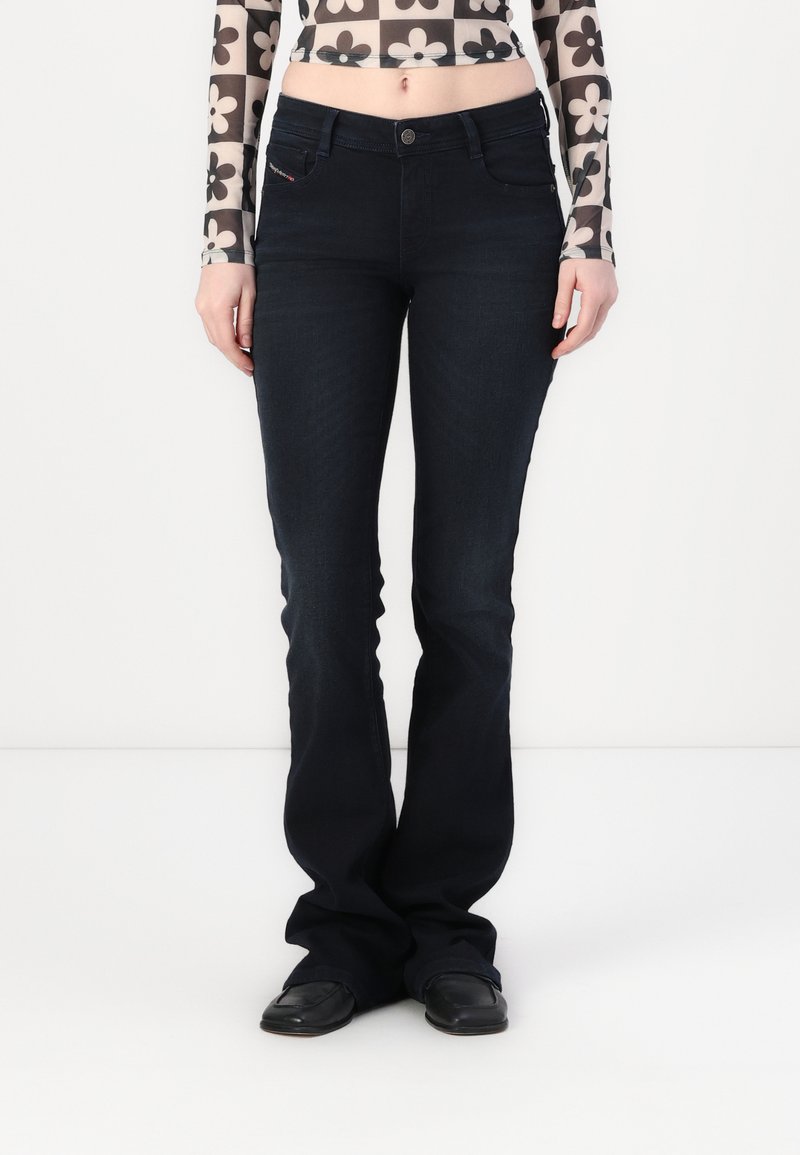 Mørkeblå flagrende jeans med en klassisk fem-lommers design. Laget av denim, med knappelukking og subtile sømdetaljer.