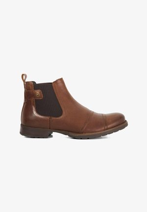 Bottines Chelsea en cuir marron avec panneaux élastiques sur les côtés et une languette de traction. Présentent un bout arrondi, une surface texturée et une semelle en caoutchouc pour une meilleure adhérence.