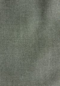 Nærbillede af tæt vævet grå-grønt tekstilstof med et subtilt diagonalt væve mønster og blød tekstur.