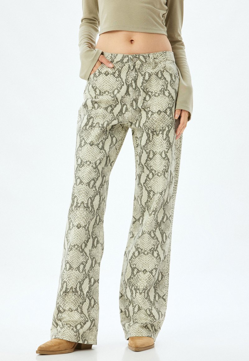 Un pantalon large présente un motif en imprimé serpent léger vert et gris. Fabriqué dans un tissu texturé, il dispose de poches latérales et d'une fermeture à bouton.