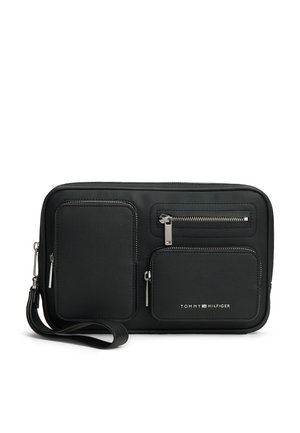 Schwarze rechteckige Handgelenktasche mit drei Reißverschlusstaschen und Tommy Hilfiger-Logo auf der Vorderseite.