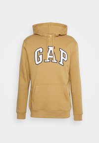 Sweat à capuche jaune moutarde, en mélange de coton. Présente le logo 'GAP' en blanc sur la poitrine, une poche avant et des poignets côtelés.