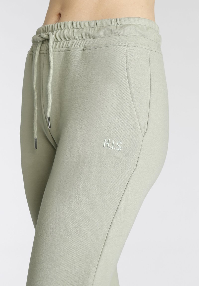 Hellgrüne Sweatpants mit elastischem Bund, Kordelzug, Seitentaschen und in passender Farbe gesticktem "H.I.S". Weiche Stricktextur.