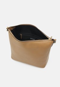 Brązowa skórzana torebka o wyraźnej, usztywnionej formie, wyposażona w zamek błyskawiczny, czarne wnętrze oraz wewnętrzną kieszeń z metką.