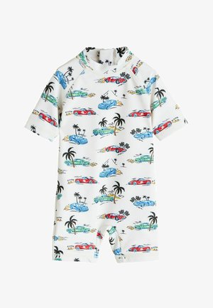 Pelele blanco de manga corta para niño pequeño con estampados coloridos de coches de carrera y palmeras, con cuello alto y cremallera en la parte posterior.