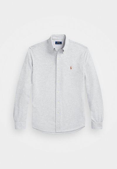 Camiseta de manga longa cinza claro com colarinho abotoável, feita de um tecido suave. Apresenta um pequeno logo vermelho no peito esquerdo e fechamento com botão.