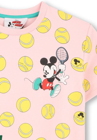 Chemise rose avec des balles de tennis jaunes et une souris de dessin animé jouant au tennis avec une raquette, chaussée de chaussures bleues et portant un short rouge.