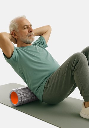 Grau Schaumstoffrolle mit orangefarbenem Innenleben auf einer grünen Matte; älterer Mann in einem teal-farbenen Shirt und grauen Hosen führt eine Übung durch, während er sich ausruht.