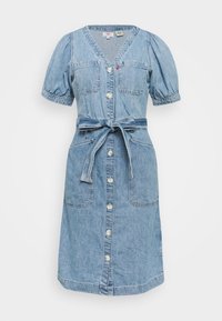 Vaaleansininen farkkumekko, jossa on lyhyet puffihihat, V-pääntie, kaksi rintataskua, napitus edessä ja solmittava vyö vyötäröllä.