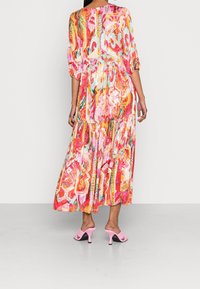 Maxikleid mit einem lebhaften, mehrfarbigen abstrakten Muster. Verfügt über Dreiviertelärmel und einen fließenden Rock, hergestellt aus leichtem Stoff.