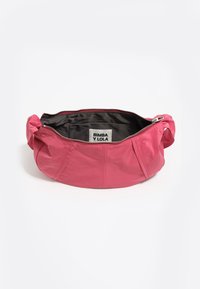 Różowa torba materiałowa o zaokrąglonym kształcie, z suwakiem i marszczeniami po bokach. Czarny wnętrze z metką z logo.