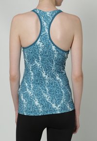 En ärmlös blå atletisk linne med ett geometriskt mönster, med racerback-design och kontrasterande kant runt halsringningen.