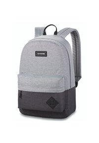 Mochila de tela gris con parte inferior gris oscuro; cuenta con un compartimento principal, un bolsillo frontal y un logo negro; correas acolchadas para mayor comodidad.