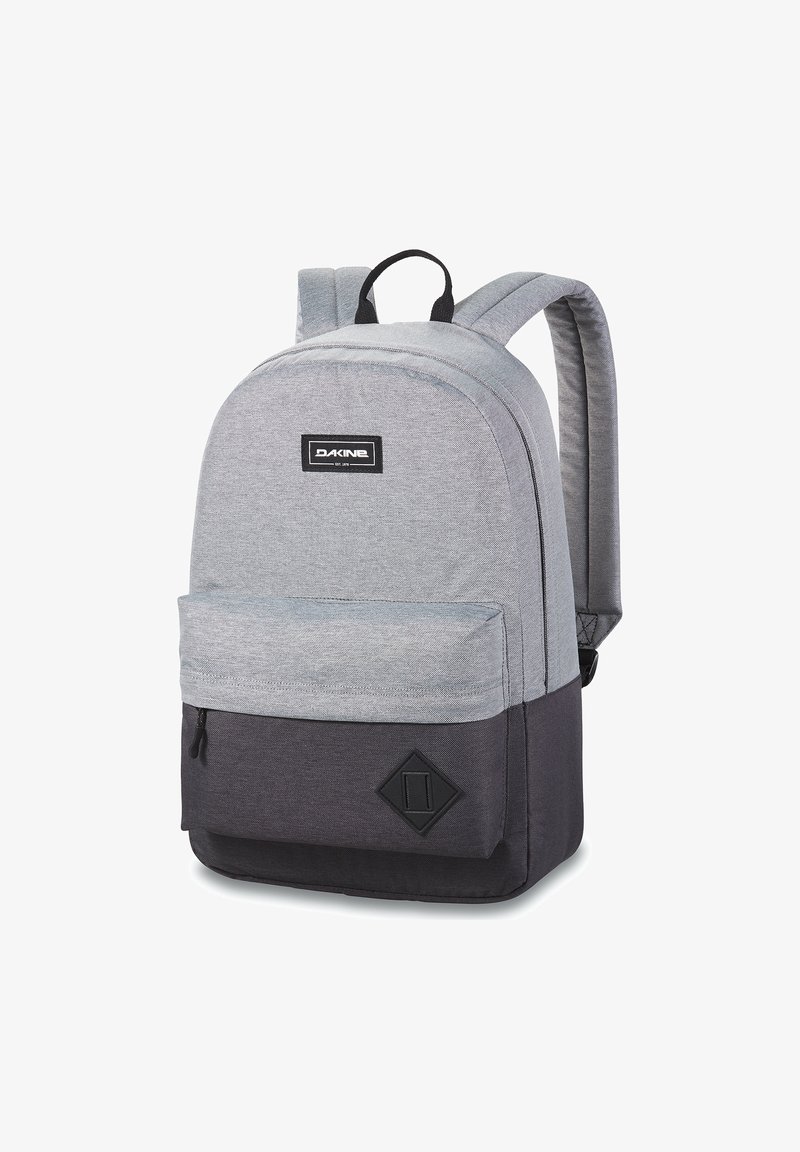 Mochila de tela gris con parte inferior gris oscuro; cuenta con un compartimento principal, un bolsillo frontal y un logo negro; correas acolchadas para mayor comodidad.
