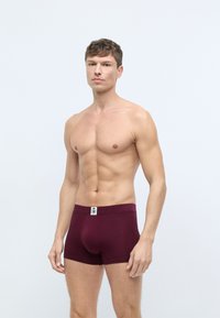 Bordeaux bomuldsboxershorts med en tætsiddende design og elastisk talje, der har et lille logo-tag. Glat tekstur og længde til midt på låret.