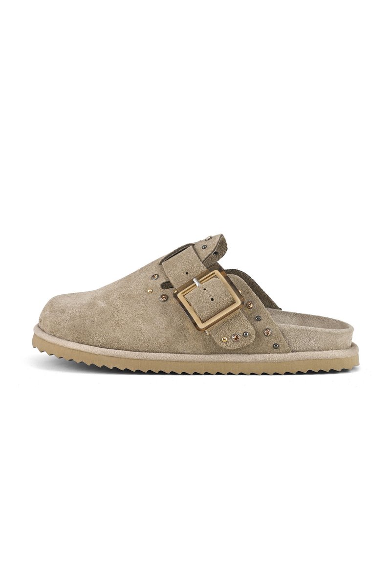 Light brown suede slip-on clog with an adjustable strap, decorative studs, and a textured sole. Features a flat profile and rounded toe.