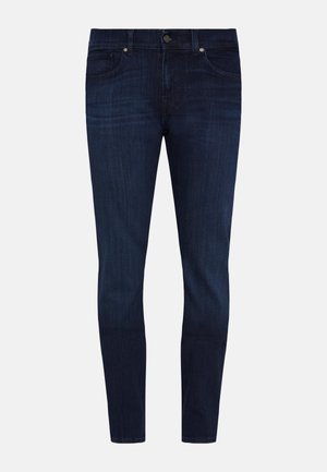 Jeans slim fit di denim di colore blu scuro. Presentano cinque tasche, chiusura con bottone frontale e leggera scoloritura sulle cosce.