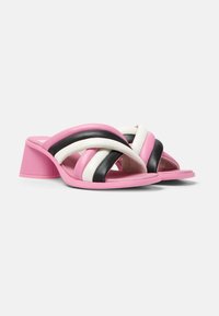 Mule rosa con tacco a spillo caratterizzata da fasce intrecciate in bianco e nero, con una finitura liscia e un tacco a blocco chunky.