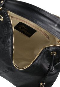 Sac à main en cuir noir avec un extérieur texturé, des accessoires en or et un intérieur beige comprenant une poche zippée et une étiquette "Fabriqué en Italie".