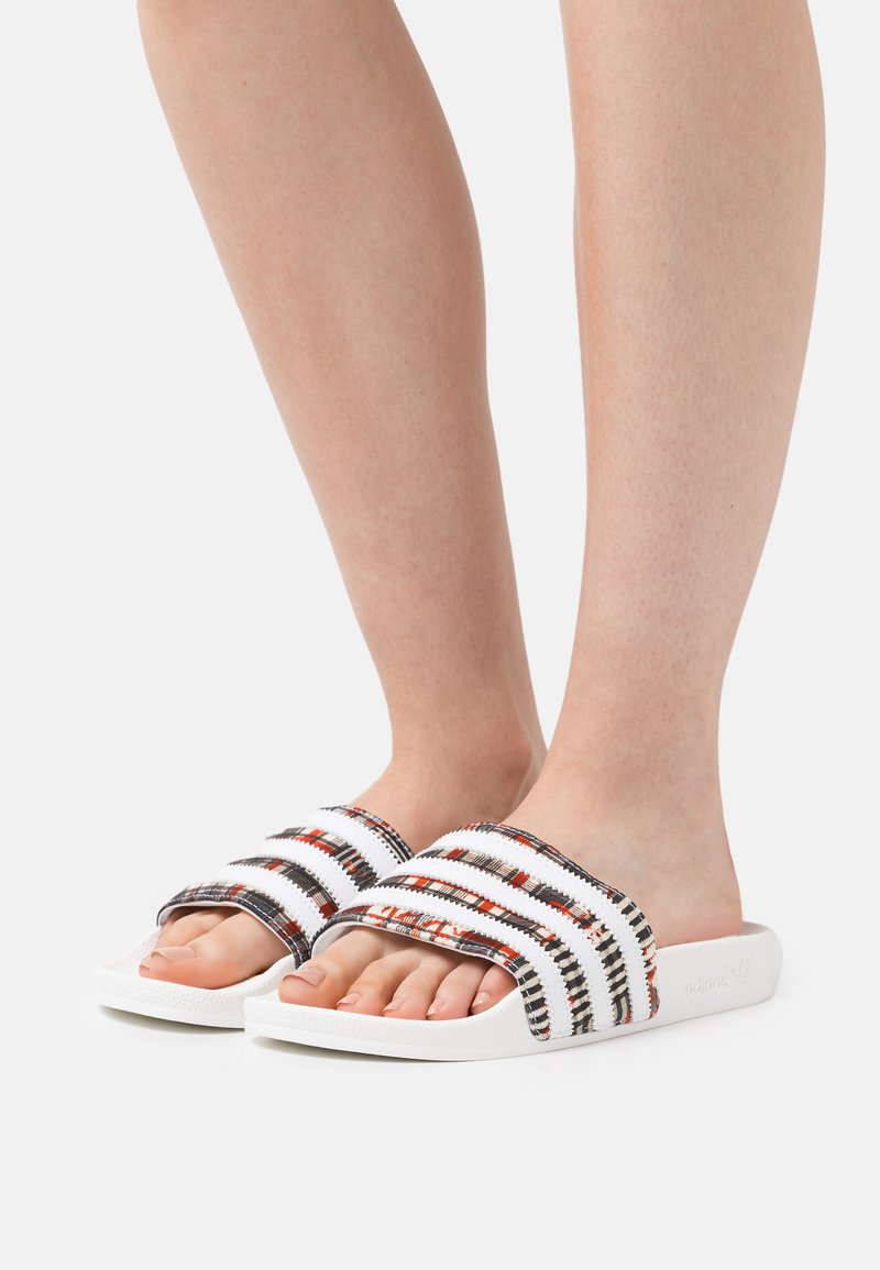 Σαμπό με λευκή σόλα, που διαθέτει πολύχρωμο πλεχτό πάνω μέρος με μαύρες, κόκκινες και λευκές ρίγες. Σχεδίαση ανοιχτού δαχτύλου.