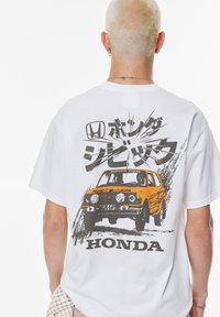 Hvid t-shirt med et grafisk print af en orange Honda Civic bil, prydet med fed sort tekst og bevægelseseffekter på bagsiden.